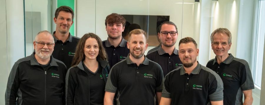 Das enschotec-Team in schwarzen Firmenshirts im Büro