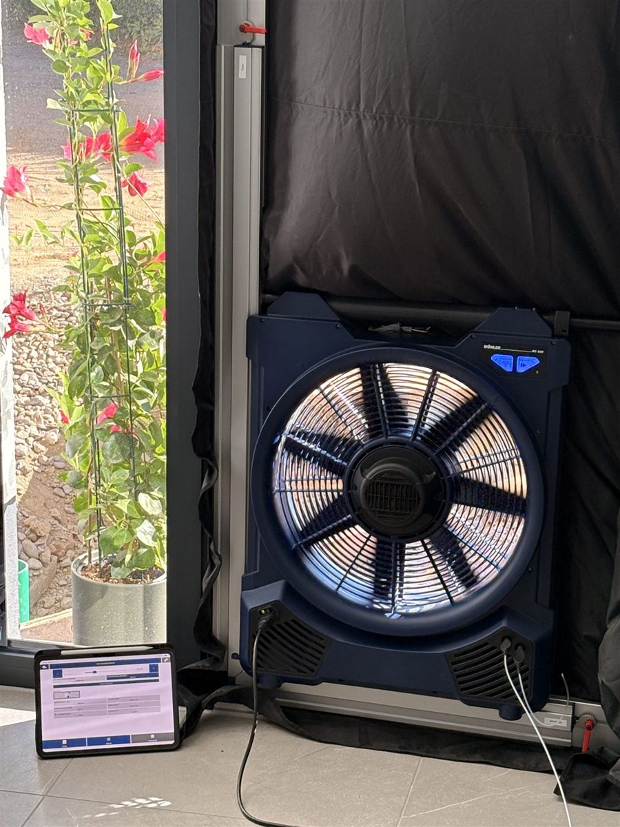Blower-Door-Gebläse im Türrahmen, davor das Tablet für die Messung