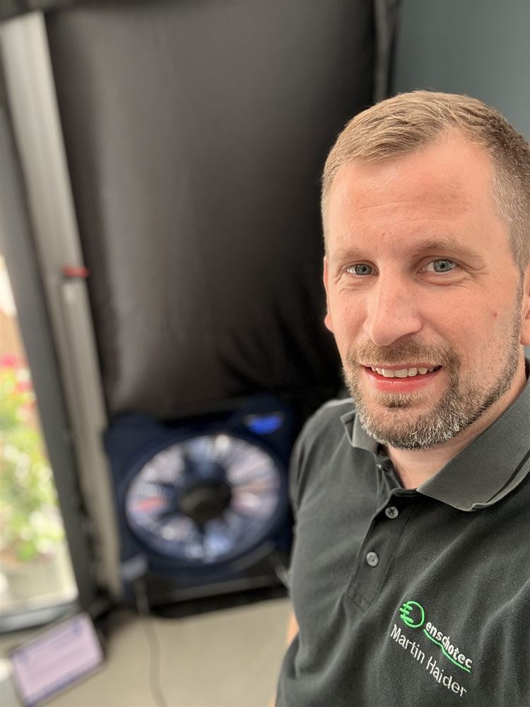 Martin Haider, Schornsteinfegermeister und Gebäudeenergieberater, vor einem Blower-Door-Gebläse